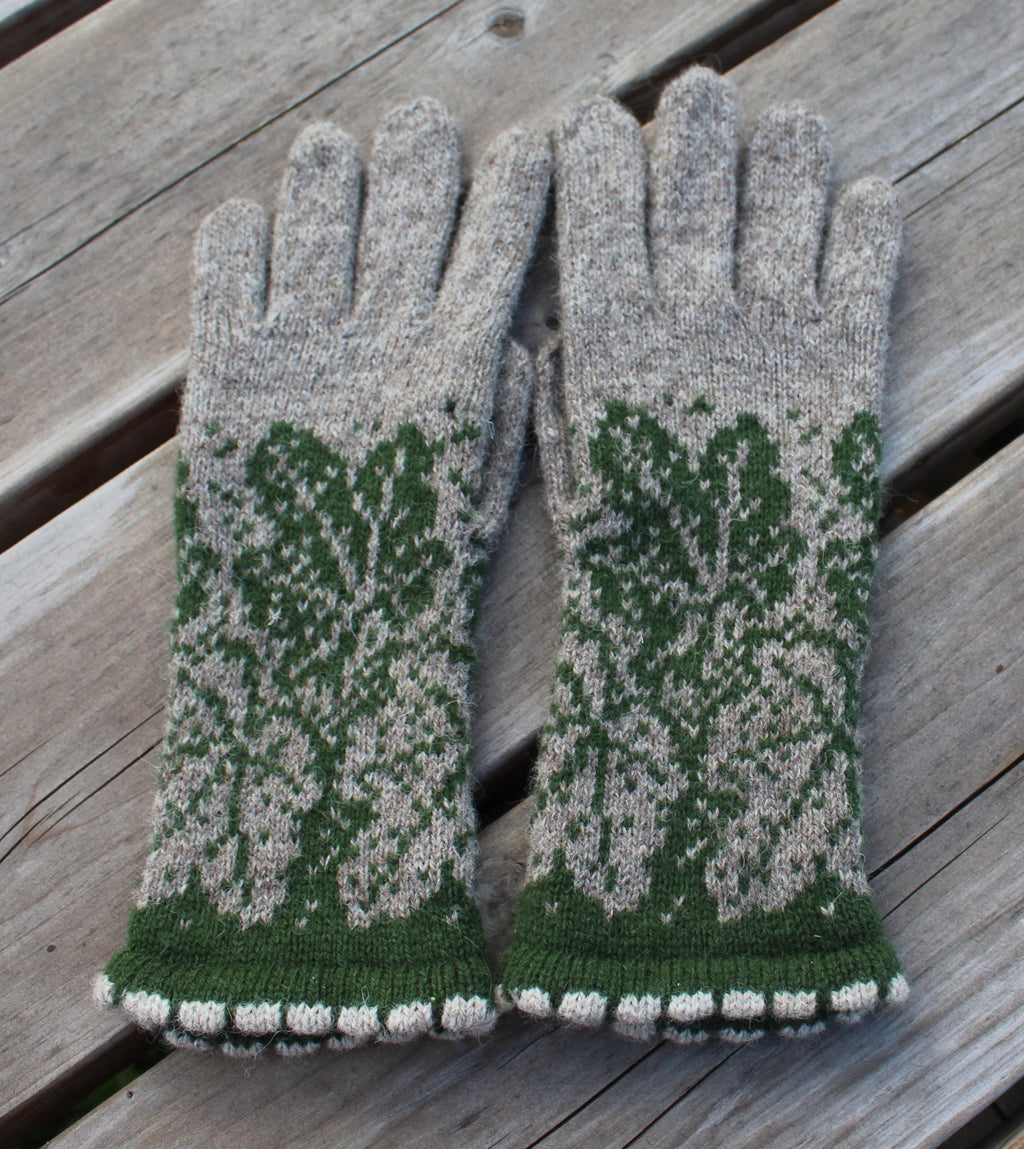 Pair of gray and green patterned gloves on a wooden surface