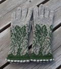 Pair of gray and green patterned gloves on a wooden surface