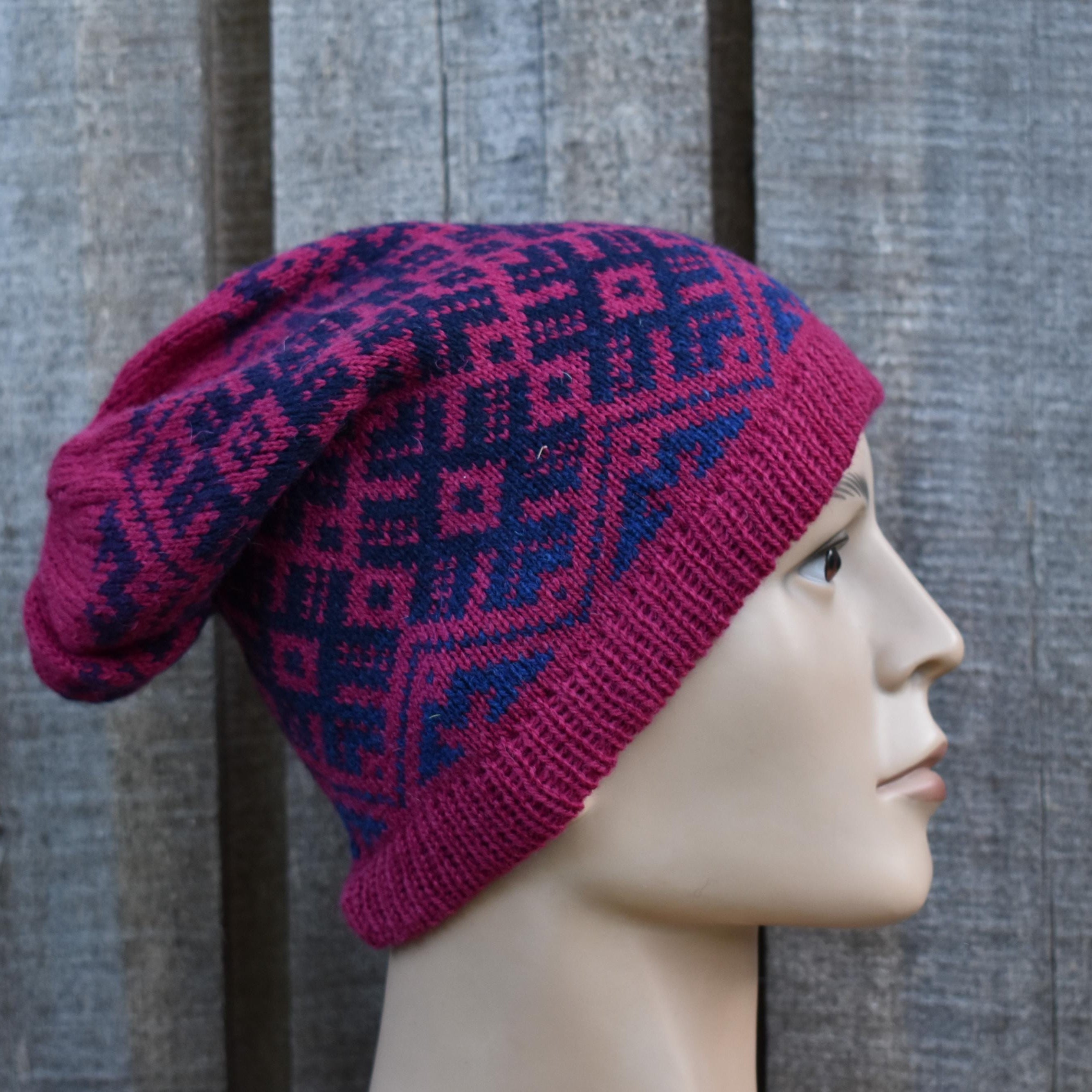 Knitted hat with geometric pattern on a mannequin head against a wooden background