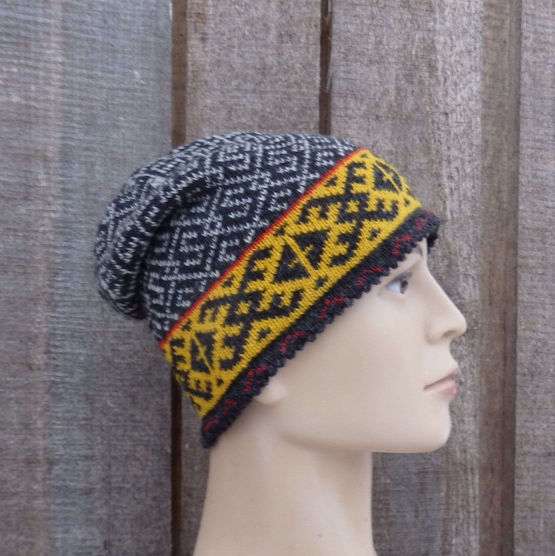 Knitted hat with geometric pattern on a mannequin head against a wooden background