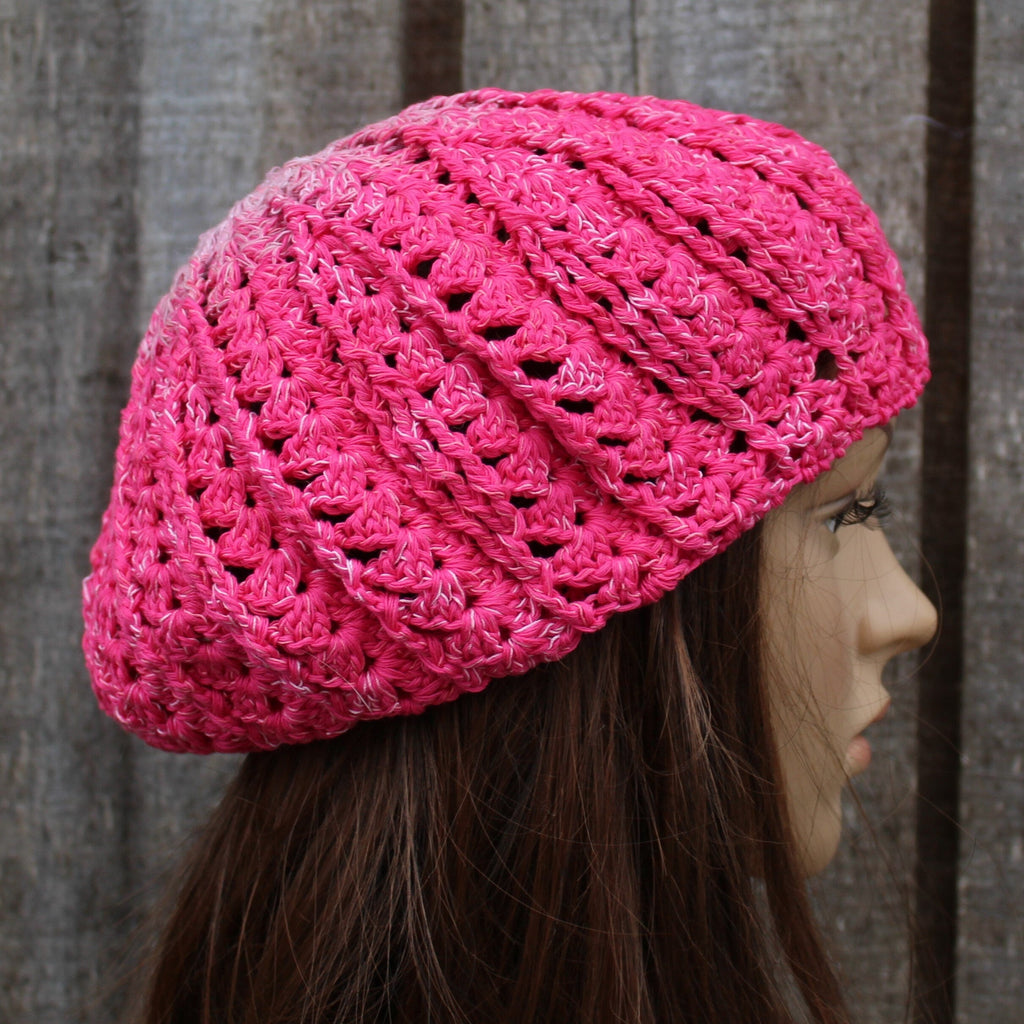 Pink knitted hat on a mannequin head against a wooden background