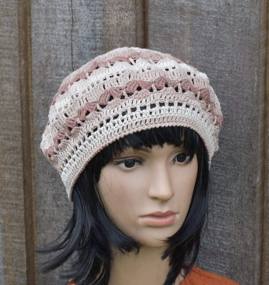 Mannequin head wearing a crocheted beanie against a wooden background
