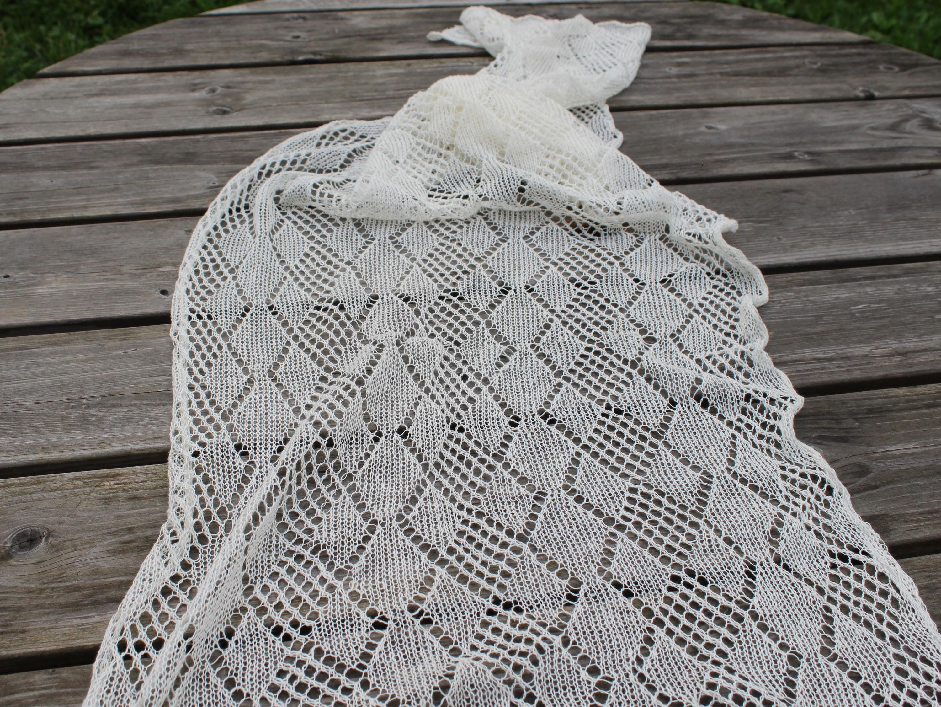 Knitted lace shawl on a wooden surface