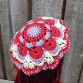 Crocheted hat with red, white, and blue pattern against a wooden background