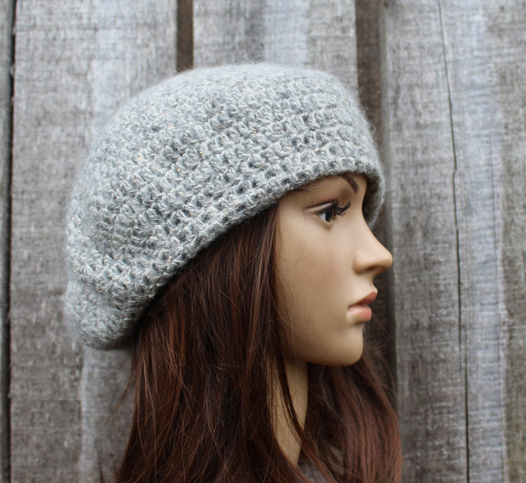 Mannequin head wearing a gray knit beanie against a wooden panel background