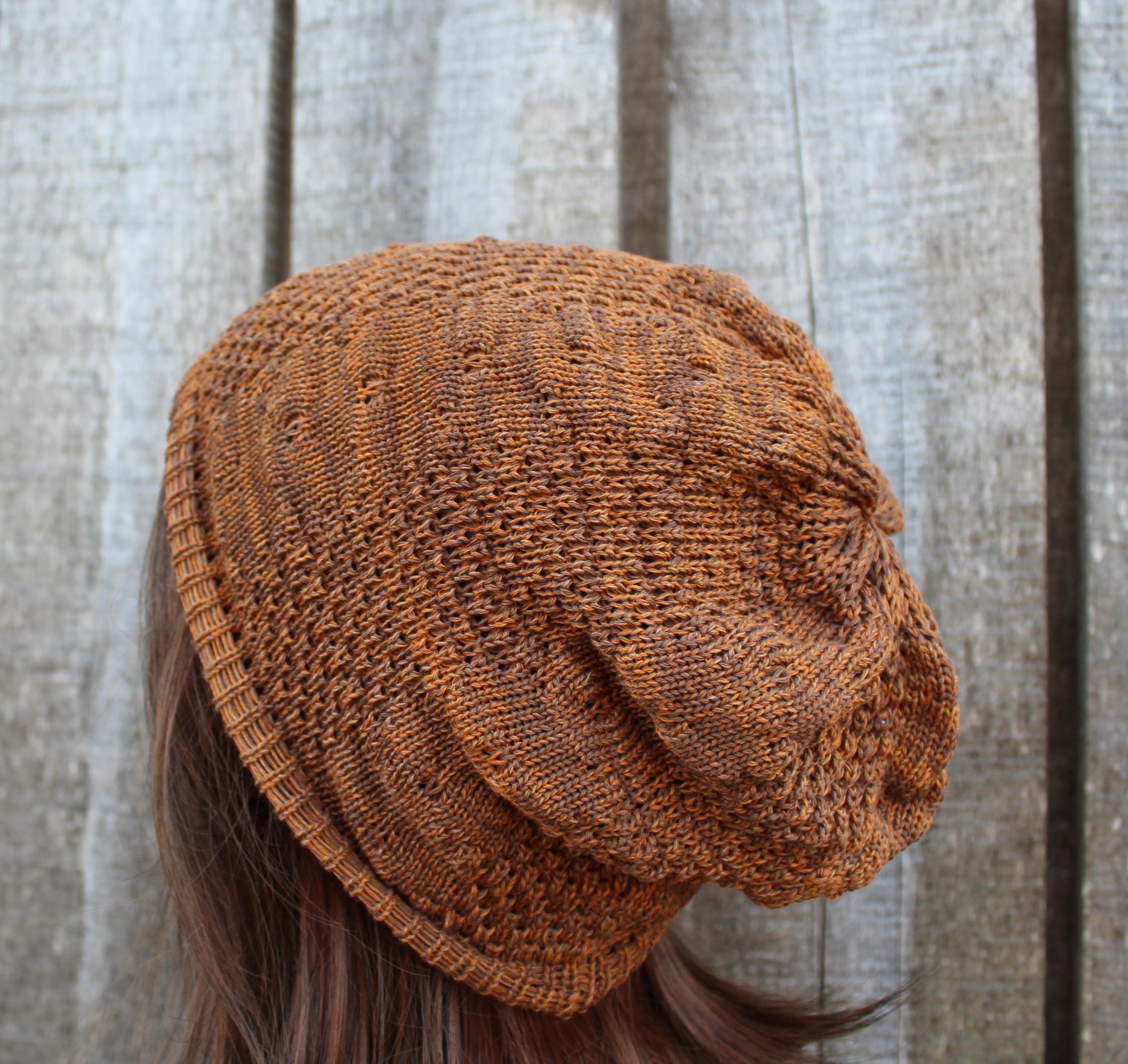 Brown knitted beanie worn by a person with a wooden background