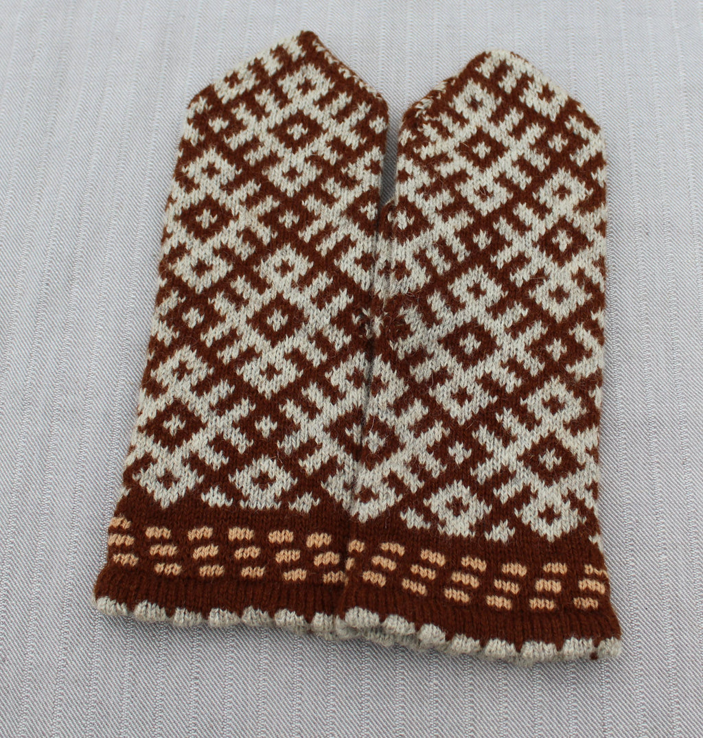 Pair of knitted mittens with a brown and white pattern on a light gray background