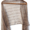 Brown knitted shawl on a wooden hanger against a white background