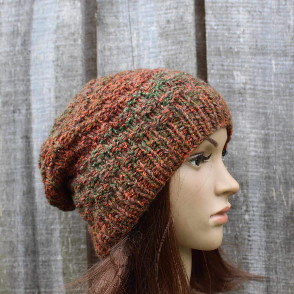 Knitted beanie on a mannequin head against a wooden panel background