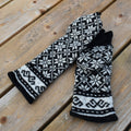 Pair of black and white patterned gloves on a wooden surface