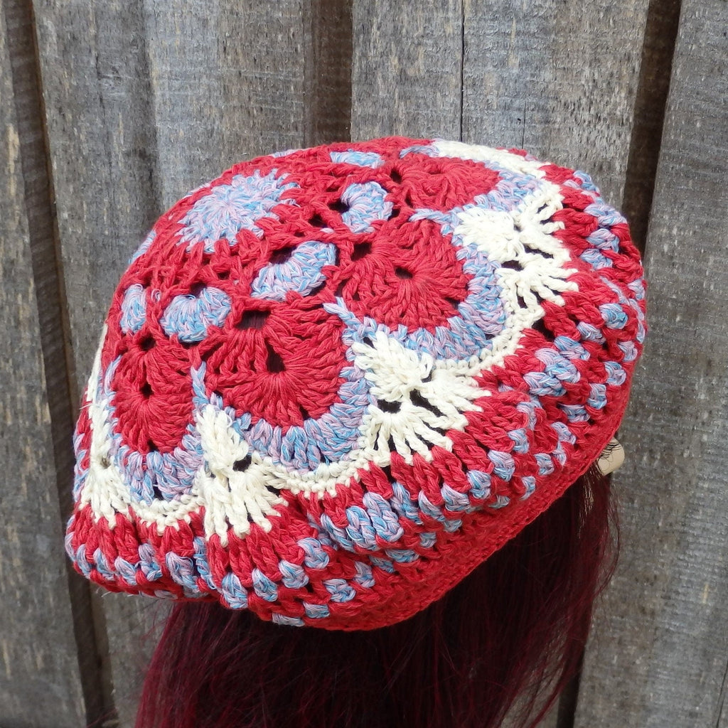 Colorful crocheted hat with red, white, and blue patterns on a wooden background