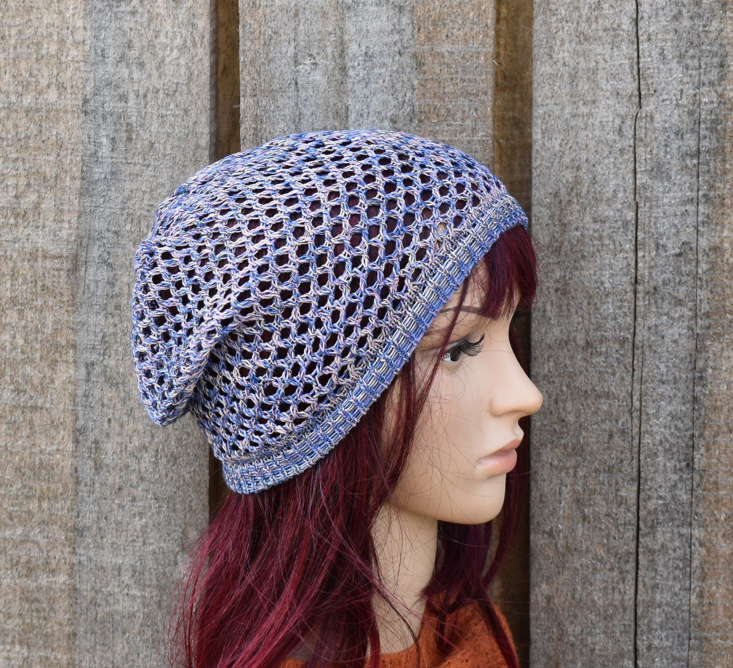 Person wearing a blue knitted hat against a wooden background