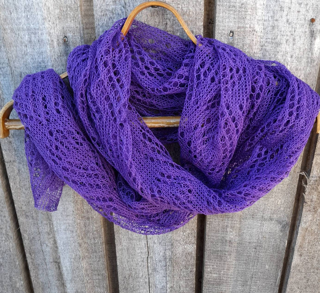 Purple lace scarf draped over a wooden surface