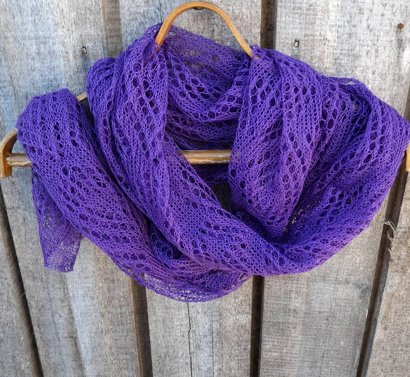 Purple lace scarf draped over a wooden surface