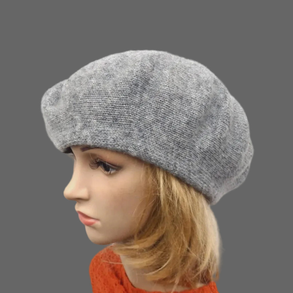 Gray beret on a mannequin head with a plain background