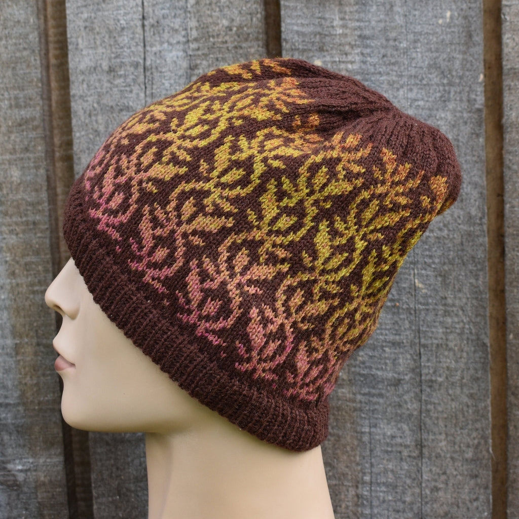 Knitted hat with a pattern on a mannequin head against a wooden background