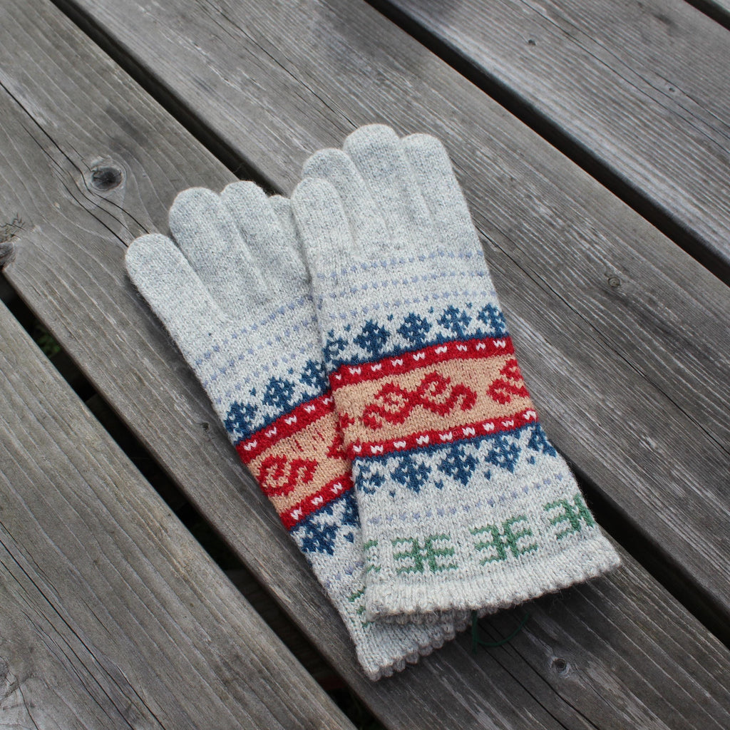 Pair of gray gloves with a colorful pattern on a wooden surface