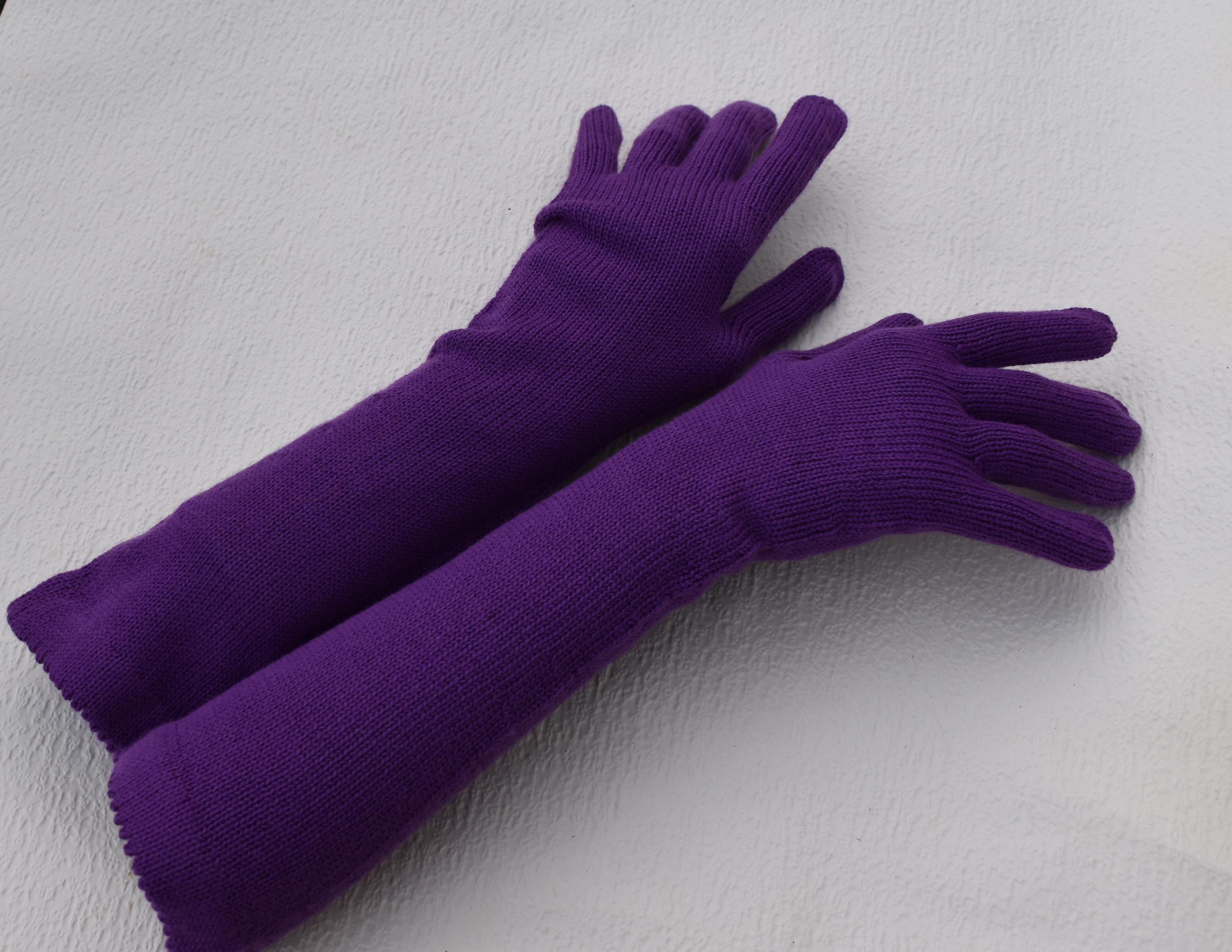 Pair of purple gloves on a light gray background