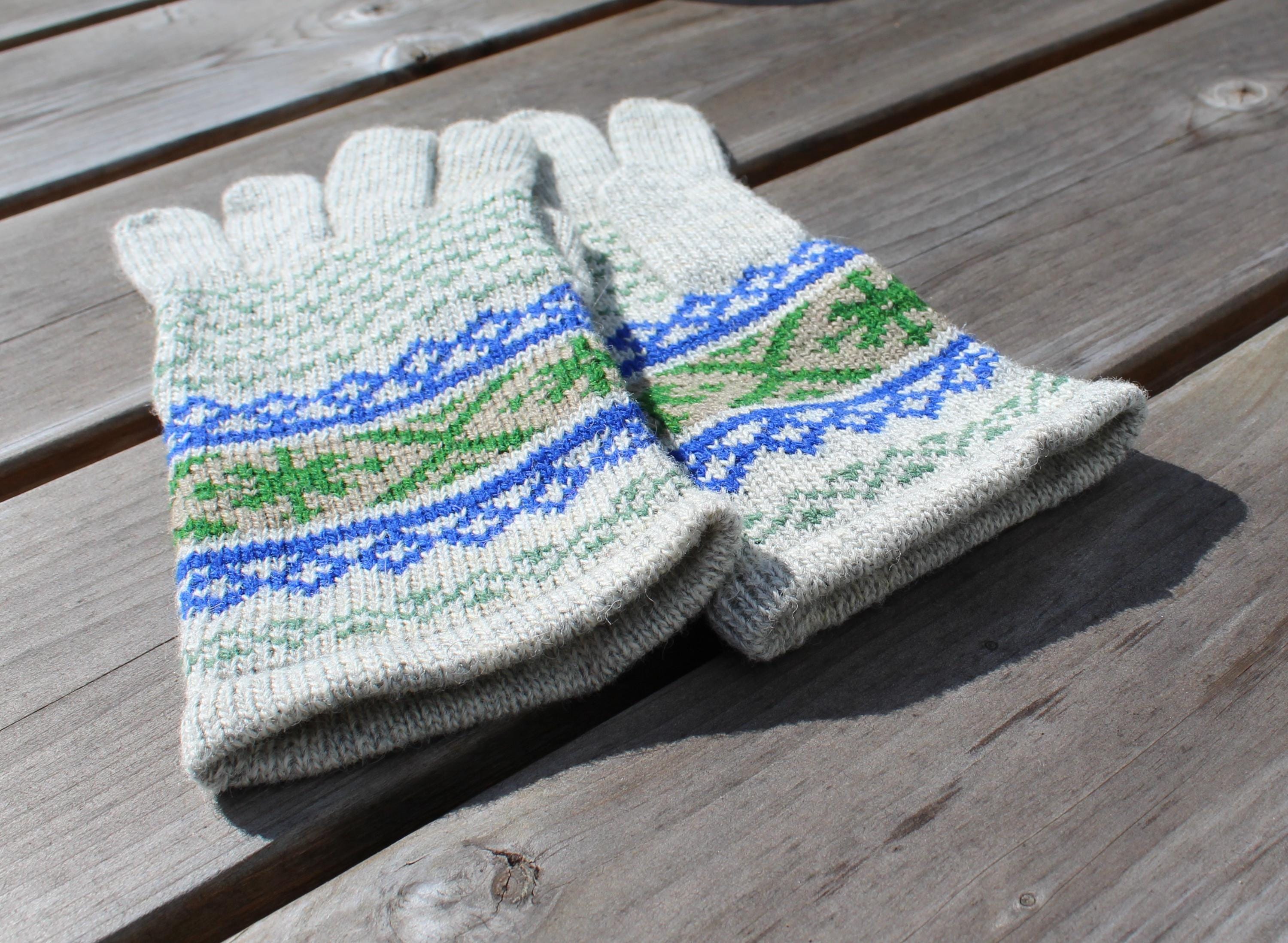 Pair of knitted gloves with a pattern on a wooden surface