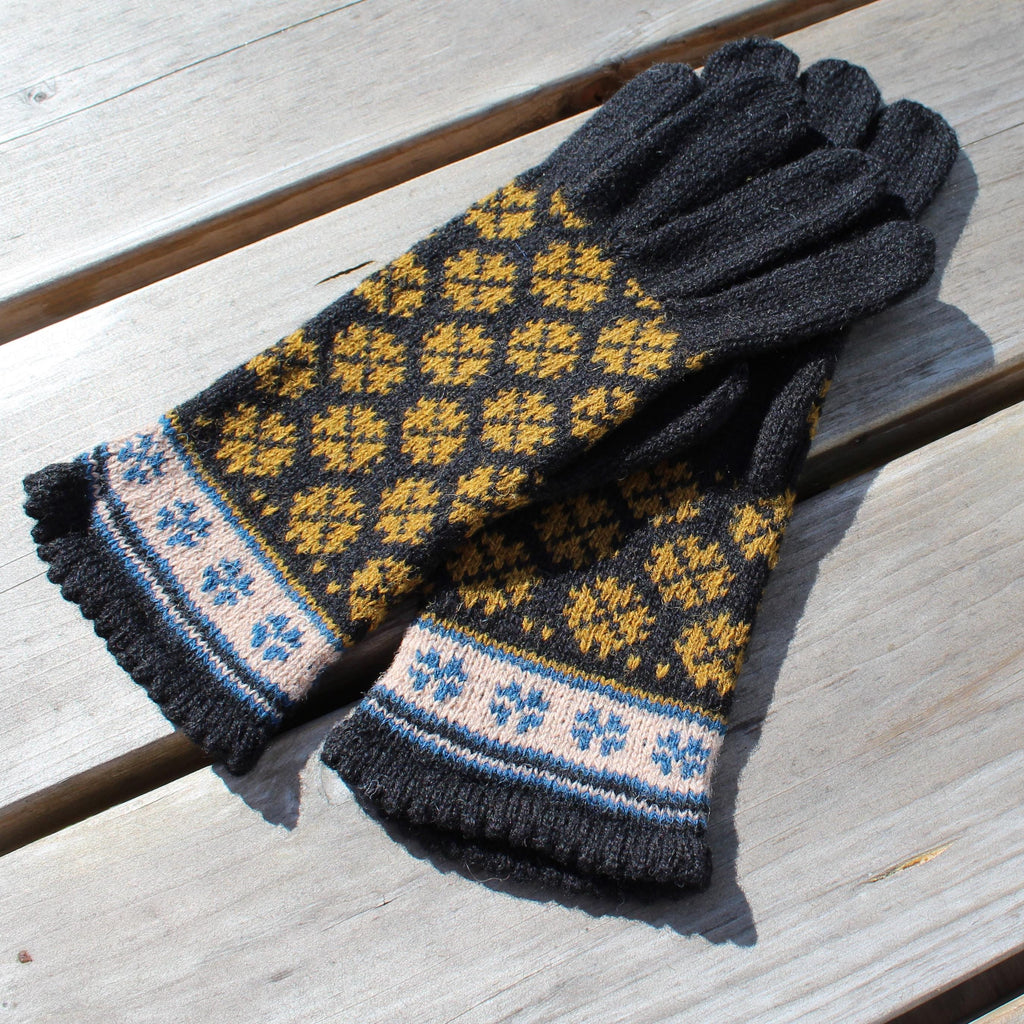 Pair of gloves with a pattern on a wooden surface