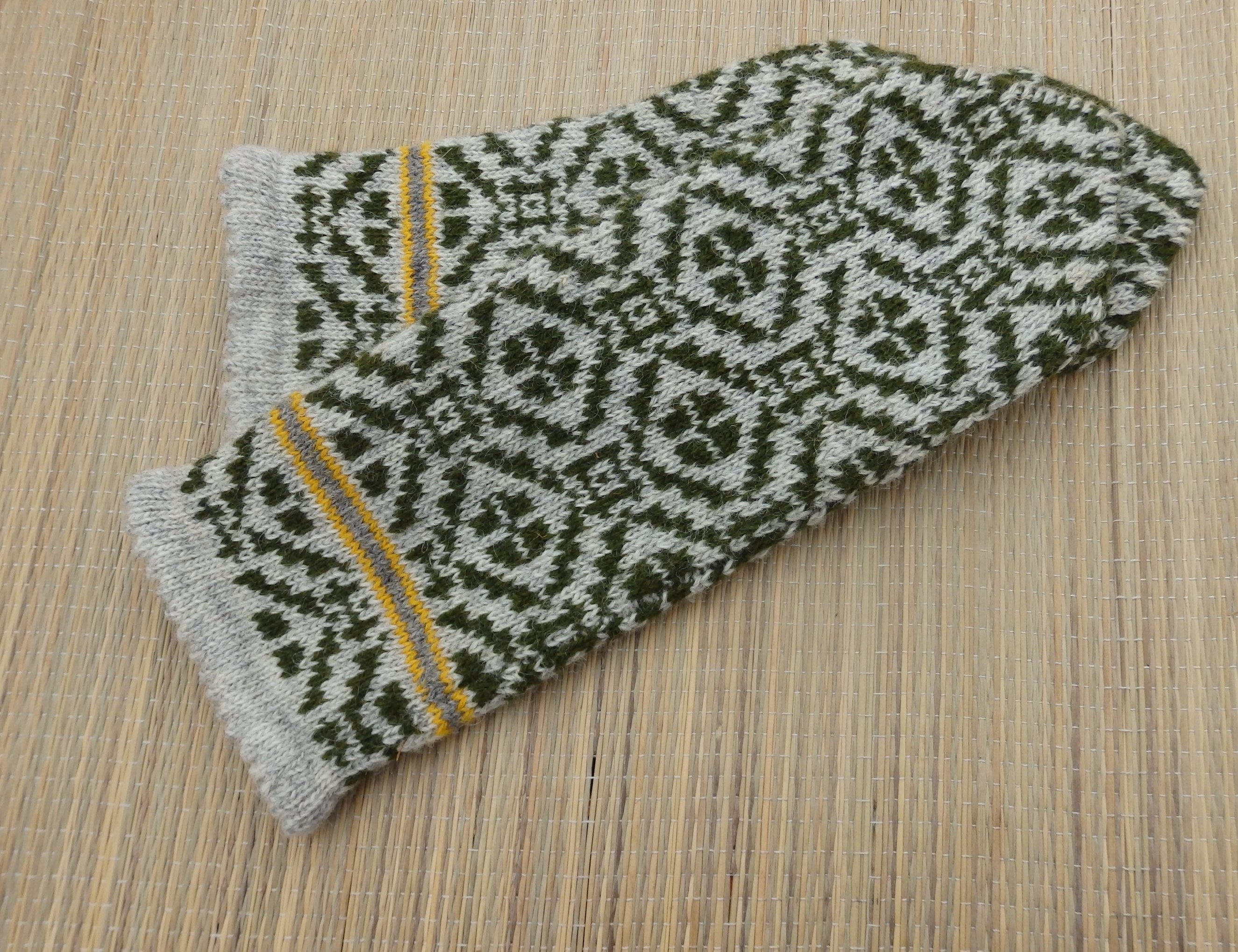 Knitted glove with a geometric pattern on a wooden surface