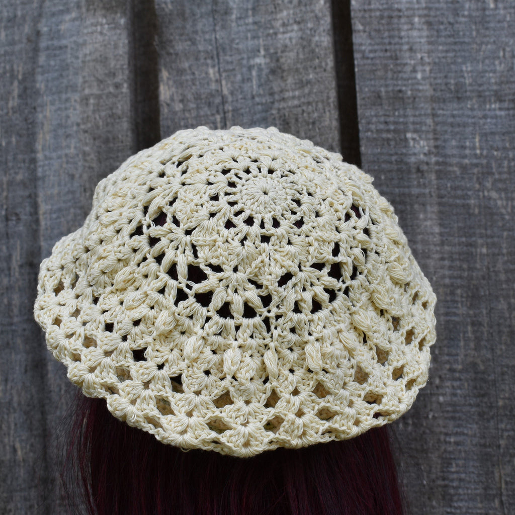 Crocheted beige hat on a dark background