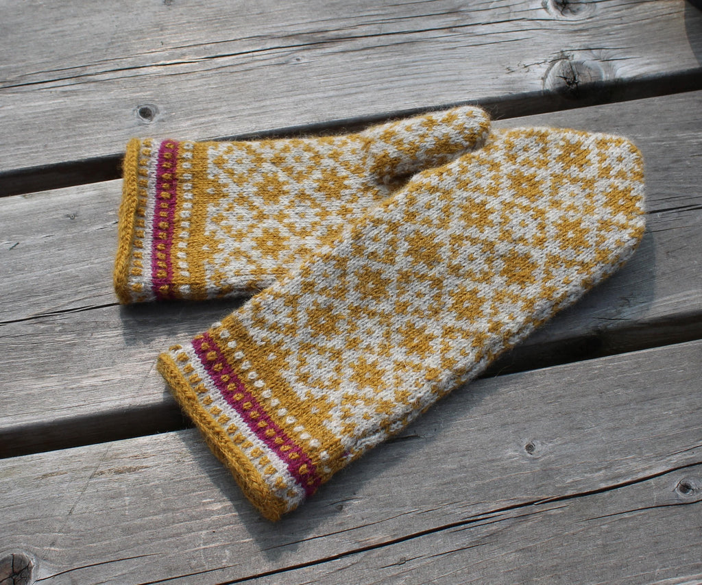 Knitted mittens with a geometric pattern on a wooden surface