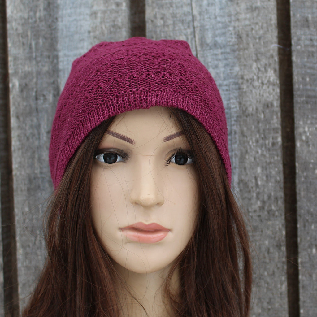 Mannequin head wearing a purple knitted beanie against a wooden background