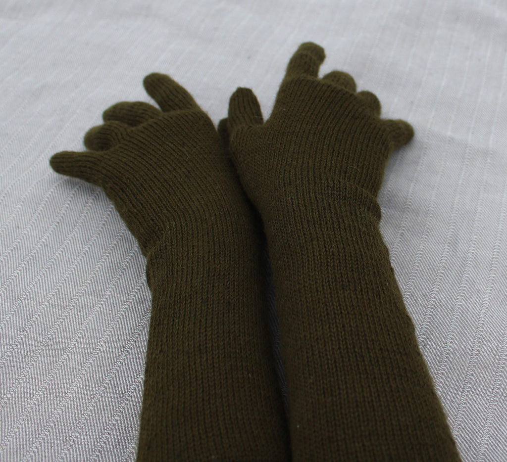 Pair of forest green gloves on a textured white background