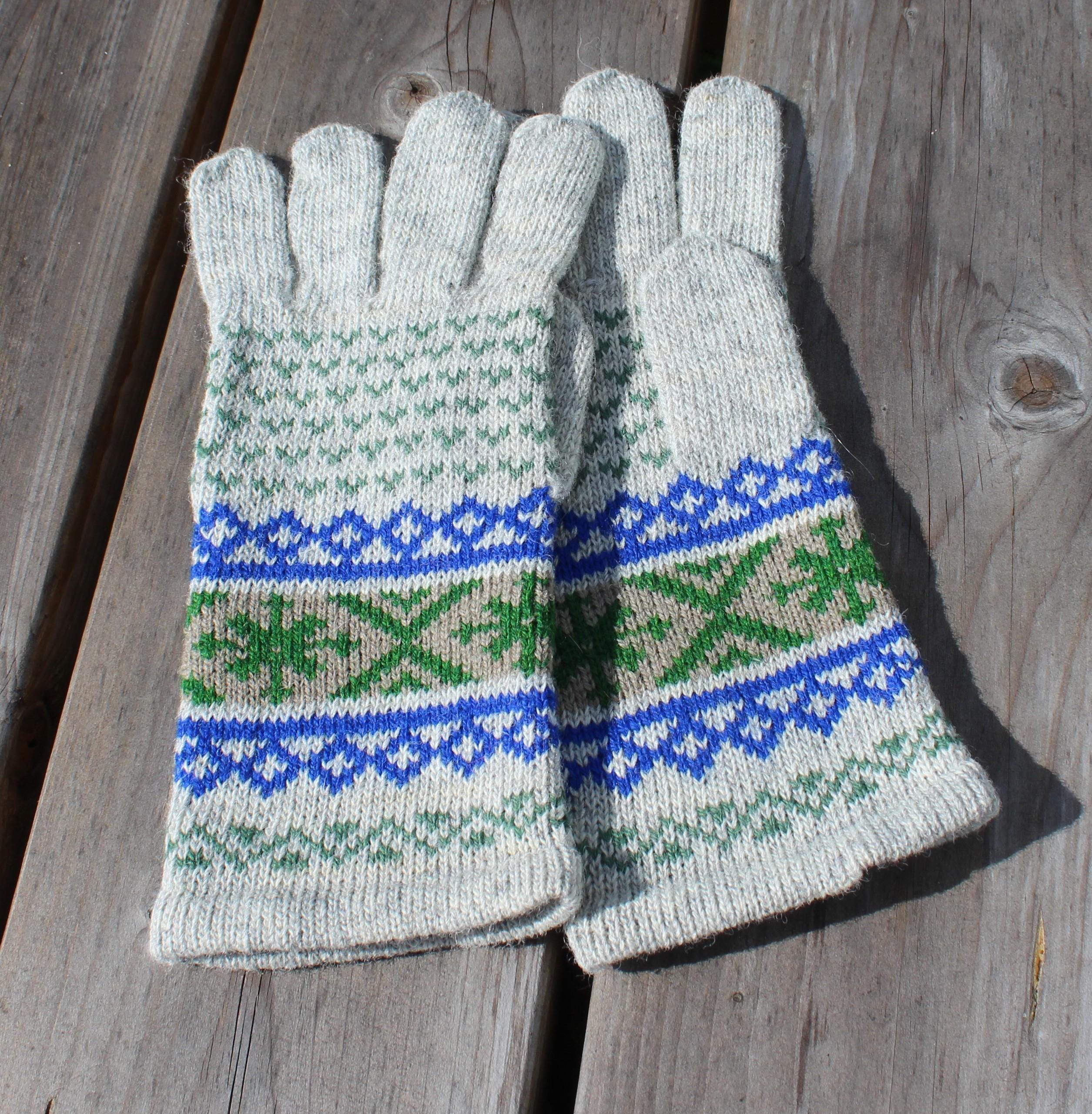 Pair of knitted gloves with a pattern on a wooden surface