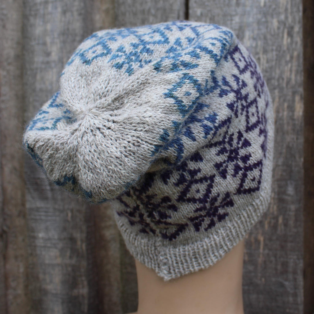 Knitted hat with blue and white pattern against a wooden background