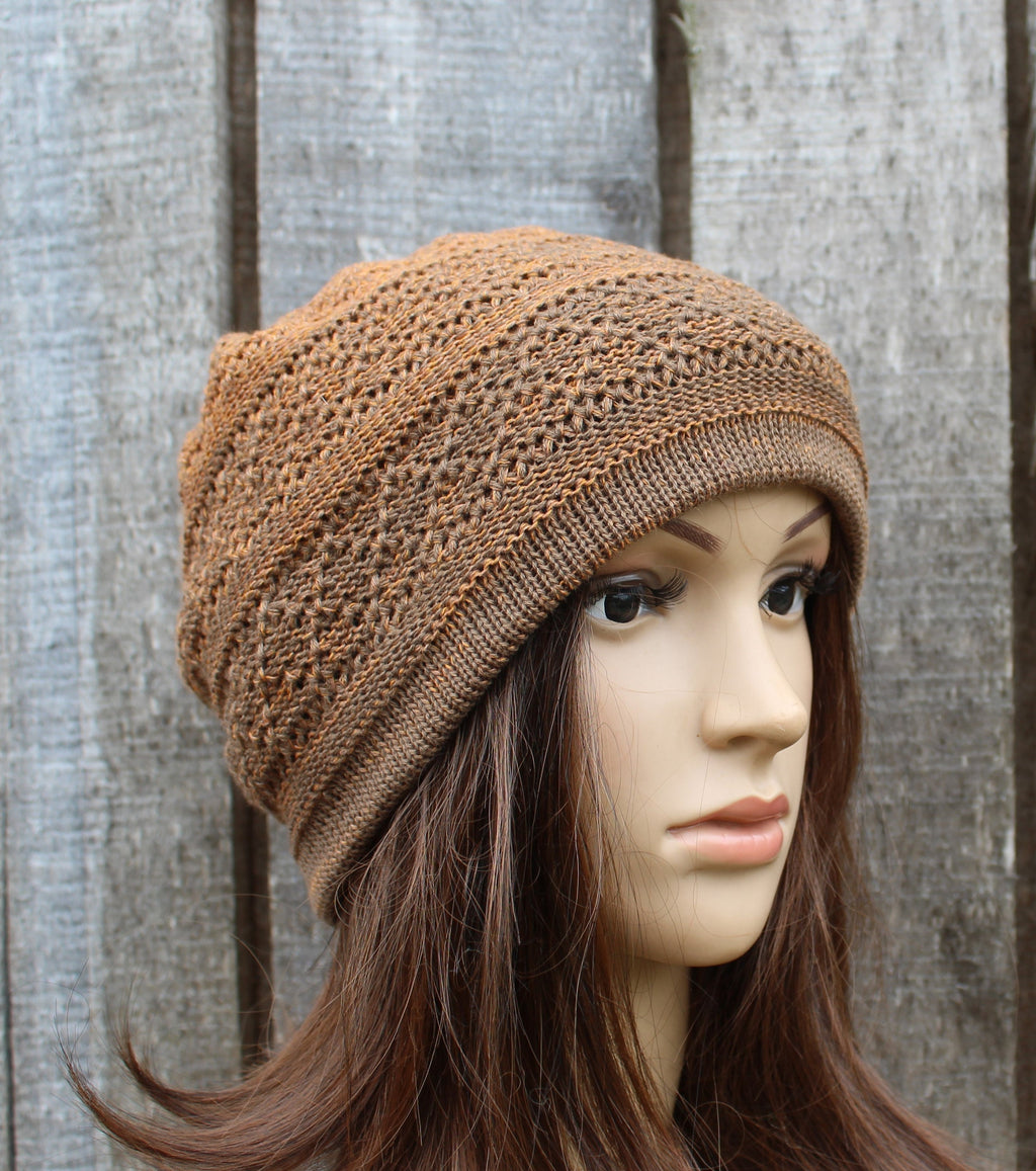 Brown knitted beanie on a mannequin head against a wooden background
