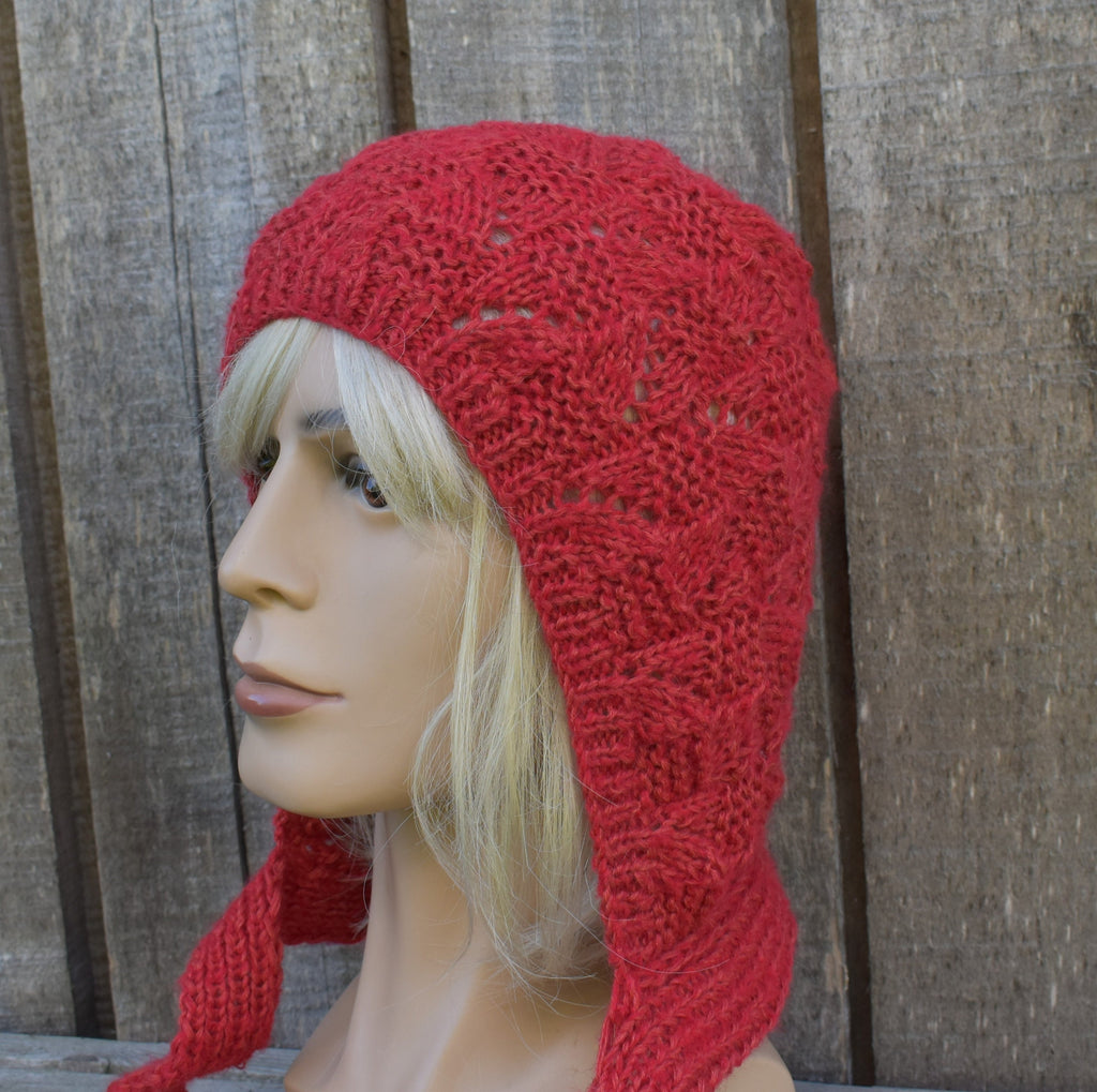 Red knitted hat on a mannequin head against a wooden background