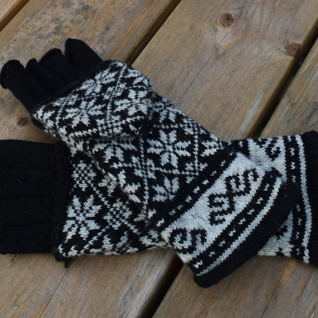 Pair of black and white patterned gloves on a wooden surface
