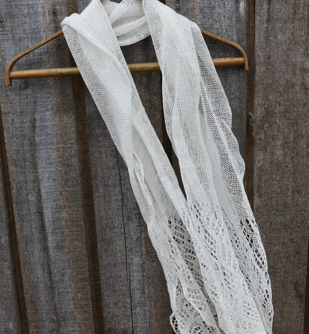 White lace scarf on a wooden hanger against a rustic wooden background