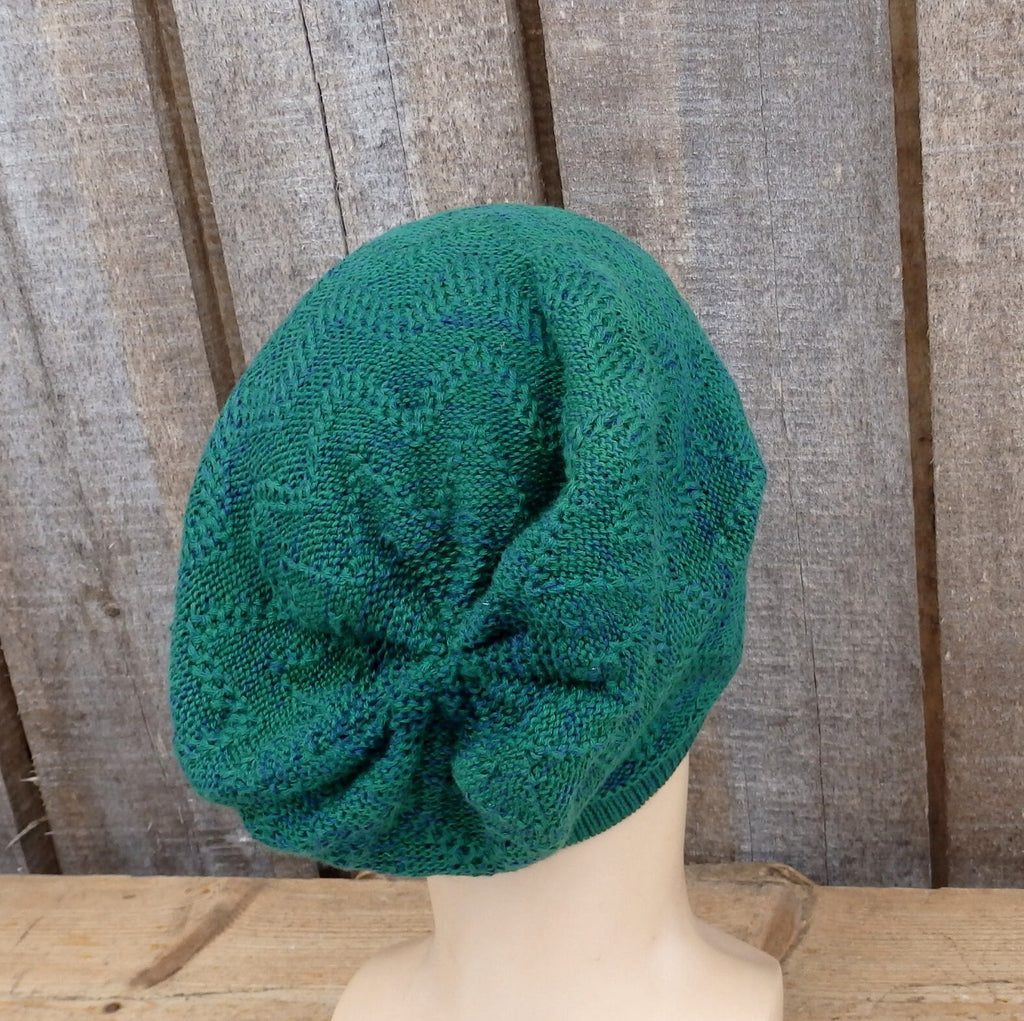 Green knitted hat on a mannequin head against a wooden background