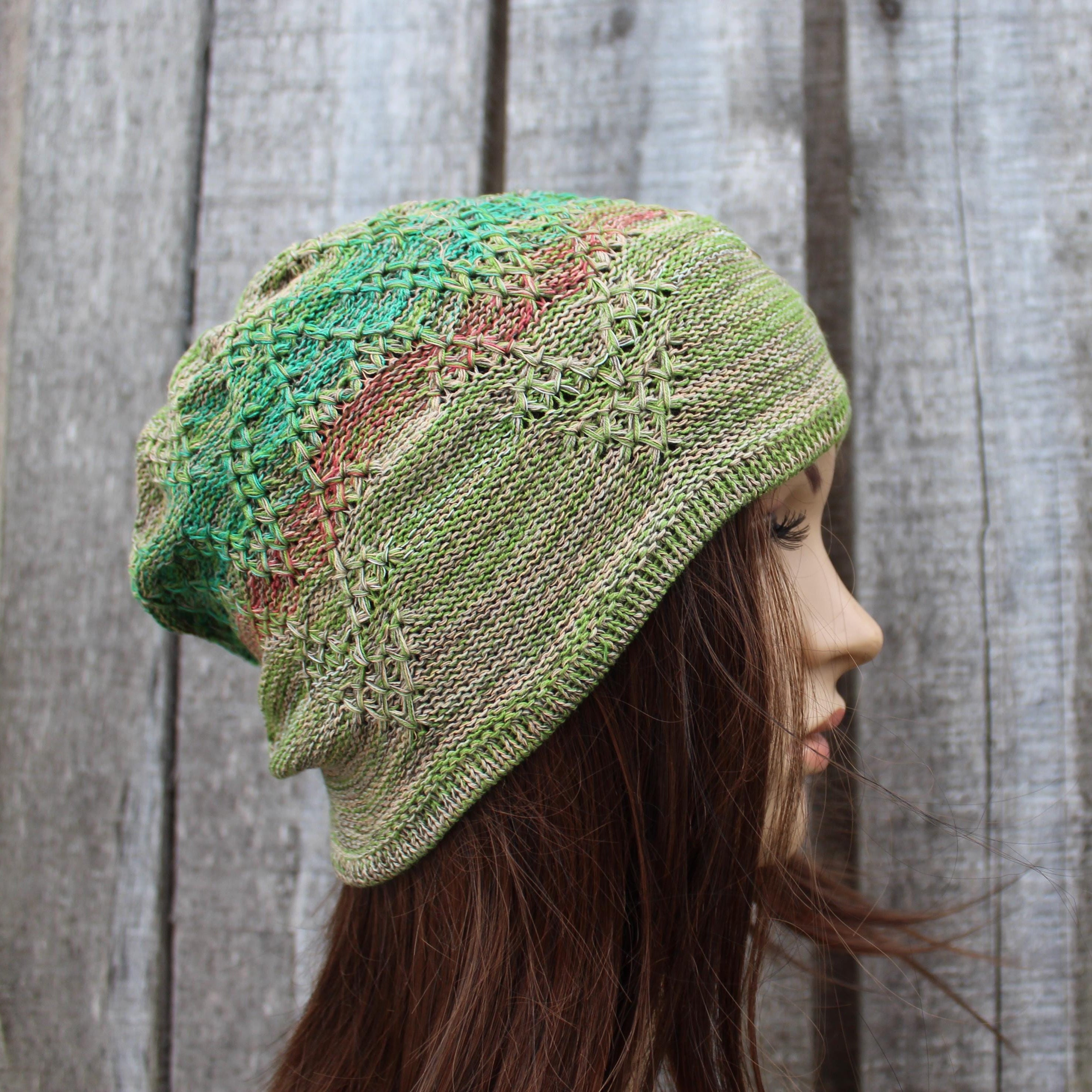 Green knitted hat worn by a person against a wooden background