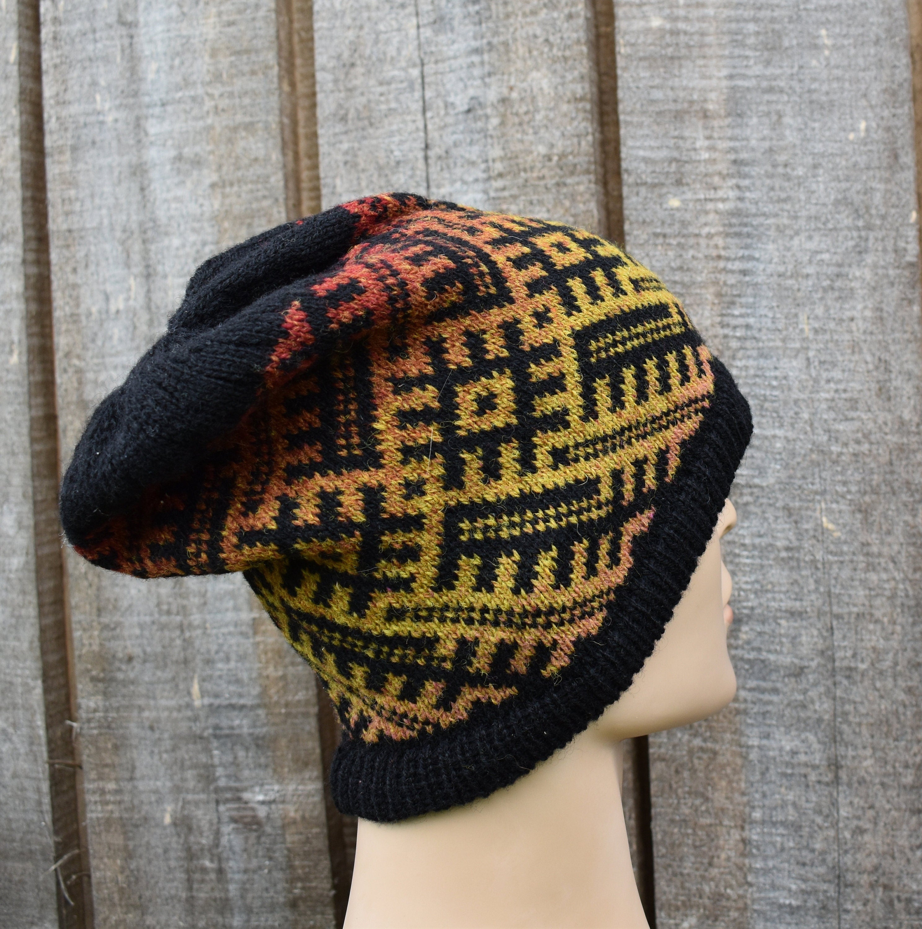 Knitted hat with geometric pattern on a mannequin head against a wooden background