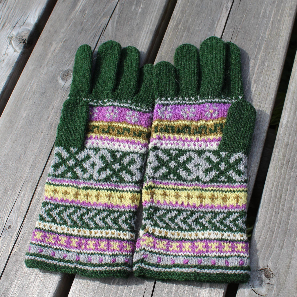 Pair of green gloves with a pattern on a wooden surface