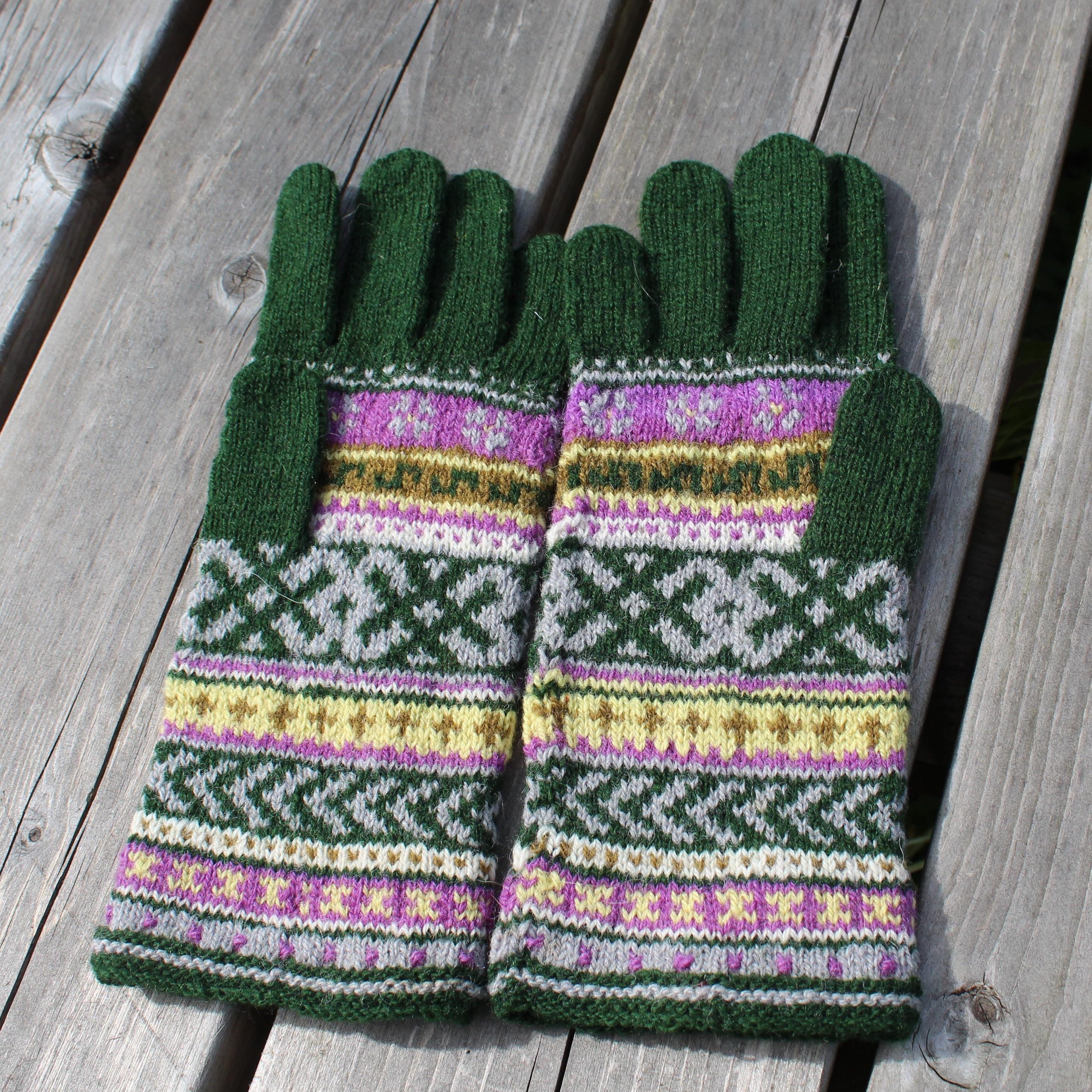 Pair of green gloves with a pattern on a wooden surface