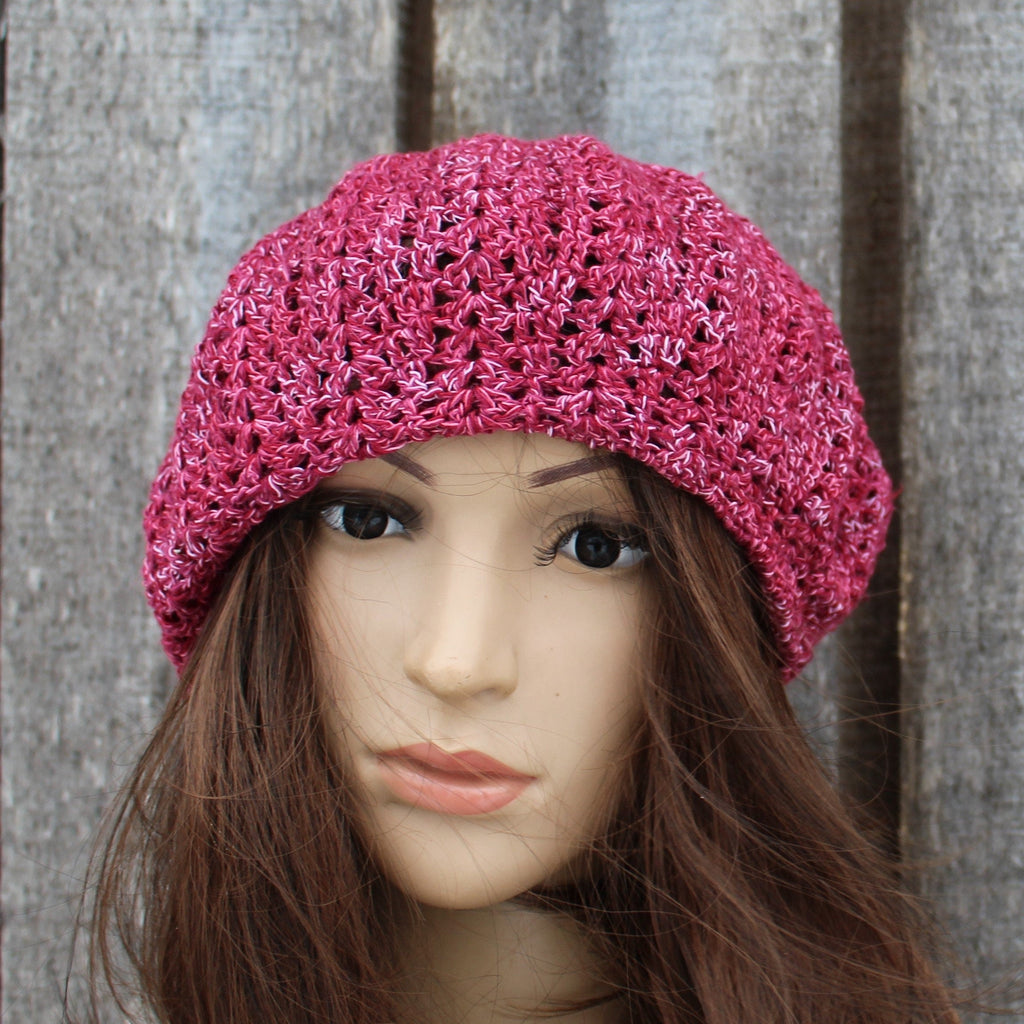Pink knitted hat on a mannequin head against a wooden panel background