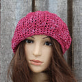 Pink knitted hat on a mannequin head against a wooden panel background