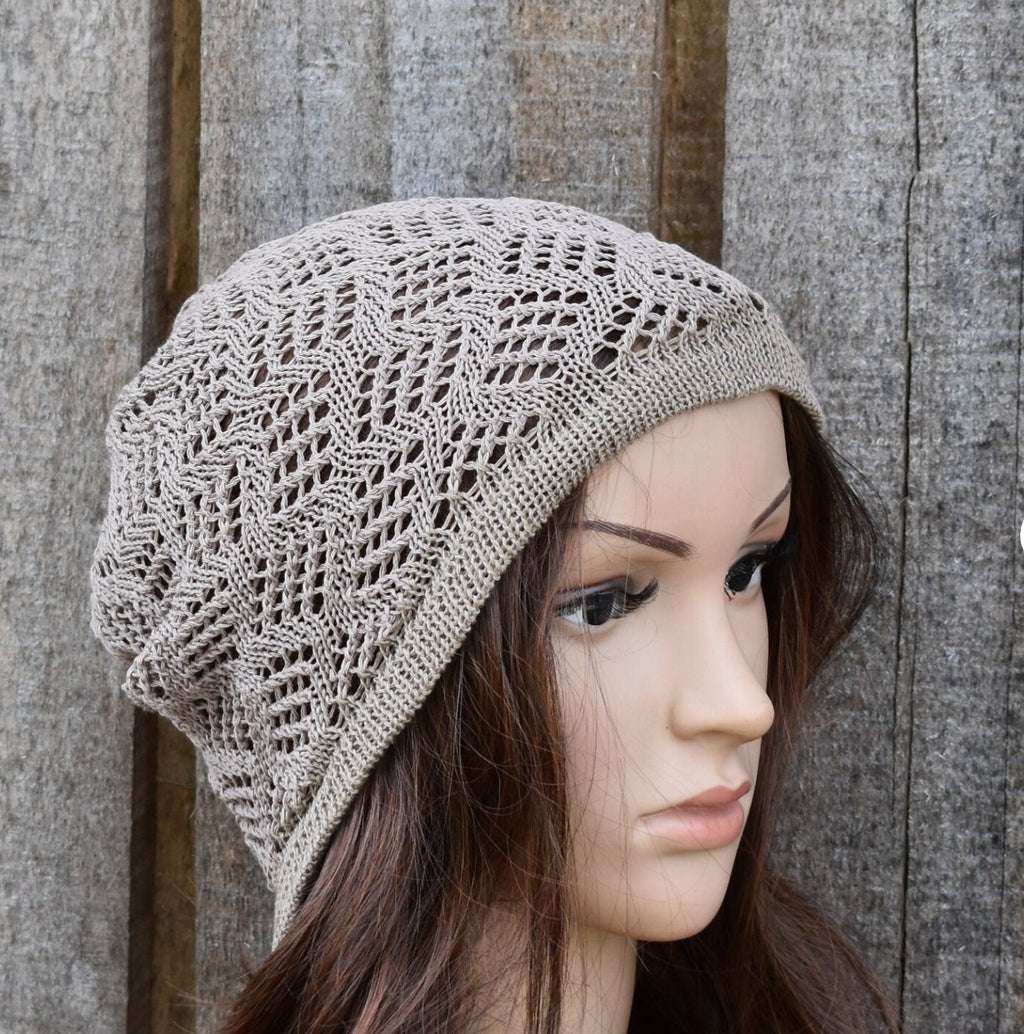 Knitted beige hat on a mannequin head against a wooden background