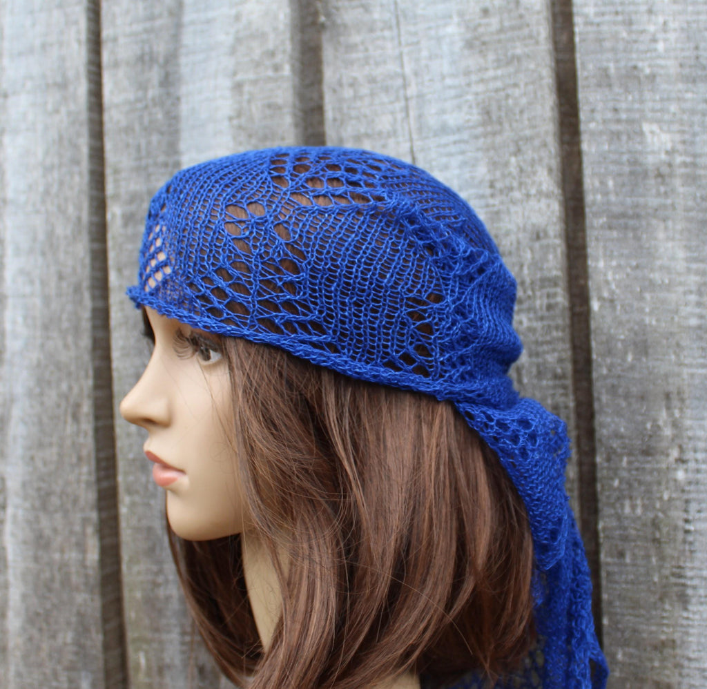 Blue knitted headscarf on a mannequin head against a wooden background