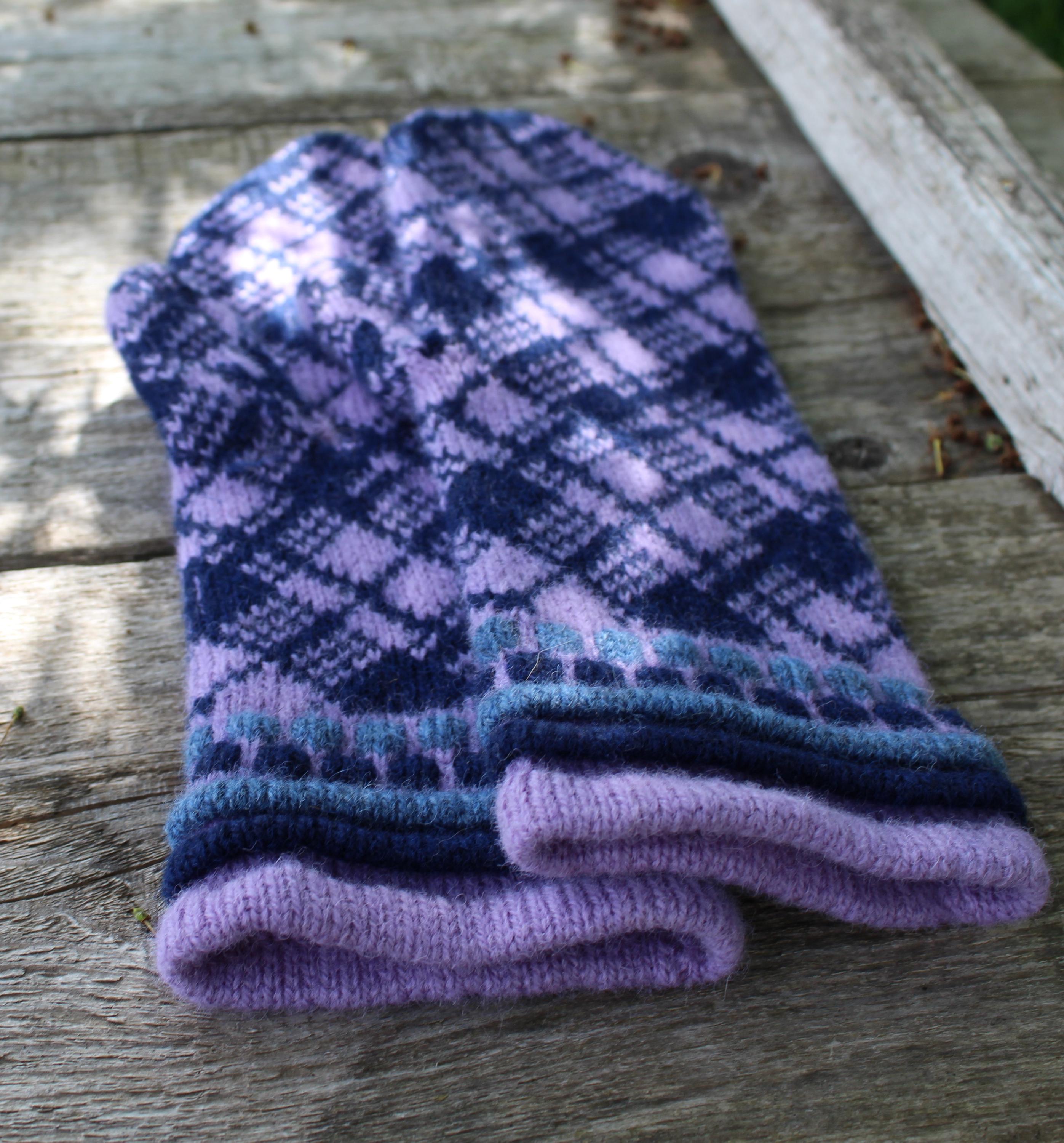 Folded purple and blue patterned gloves on a wooden surface