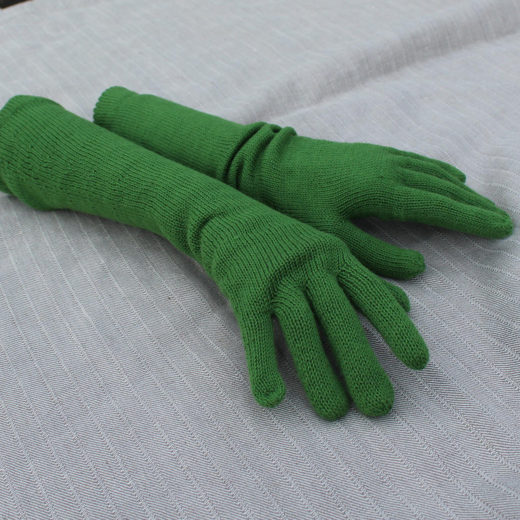 Pair of green gloves on a textured gray surface