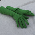 Pair of green gloves on a textured gray surface
