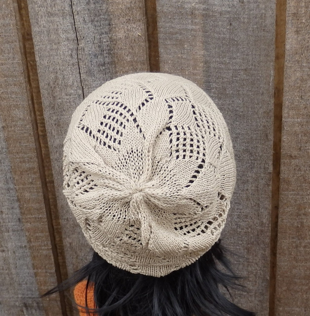 Knitted beige hat on a person against a wooden background