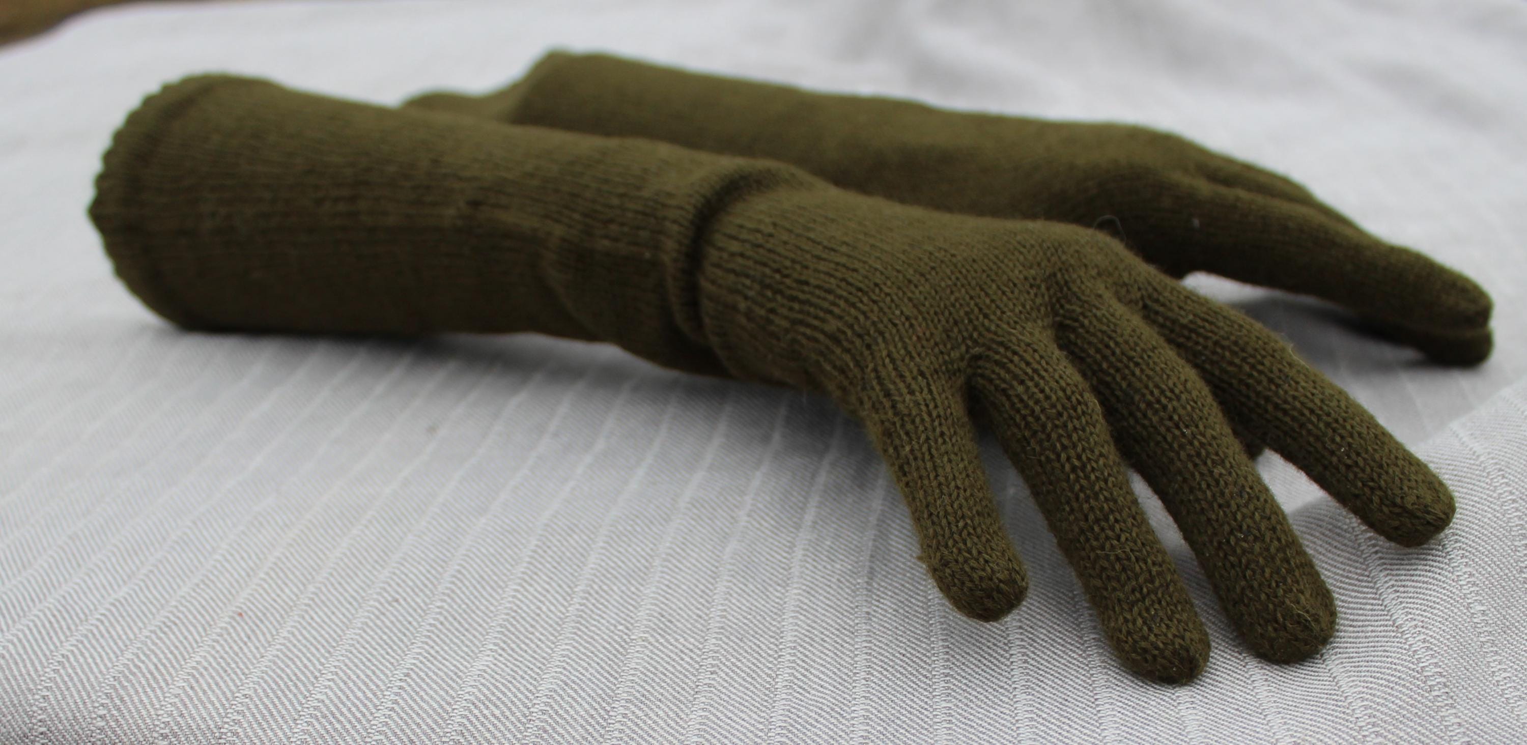 Pair of green gloves on a light gray background