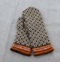 Pair of knitted mittens with a pattern on a light gray fabric background
